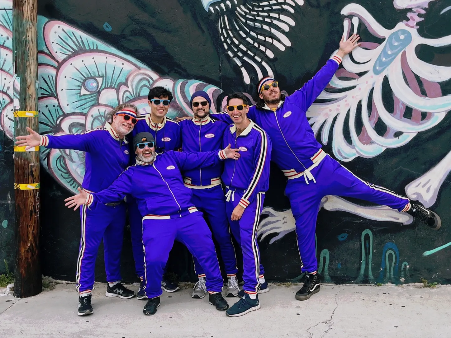 Rat Soup in matching tracksuits in front of a San Diego mural